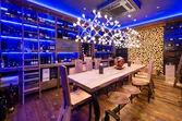 Moderner Weinkeller mit Holztisch, Designbeleuchtung und Regalen voller Weinflaschen